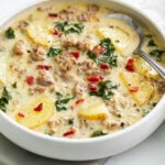 Zuppa Toscana Soup in a white bowl with sausage, potatoes, and kale.