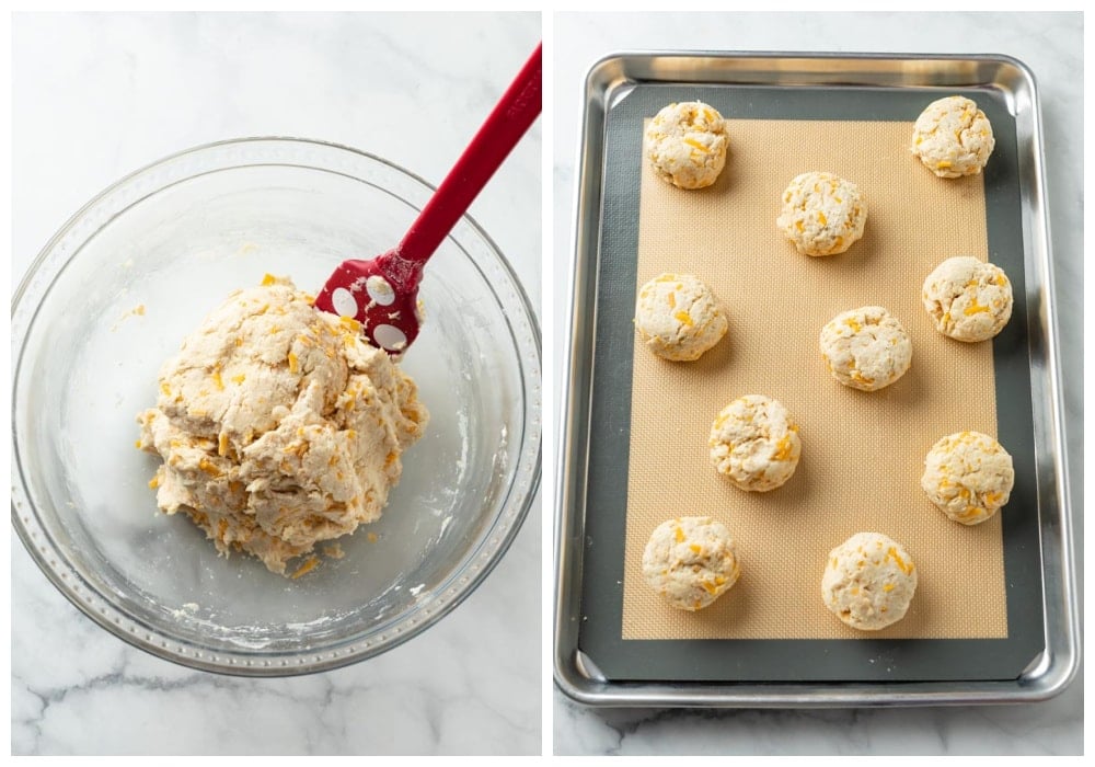 A bowl of cheddar bay biscuit dough next to a baking sheet of unbaked biscuits.