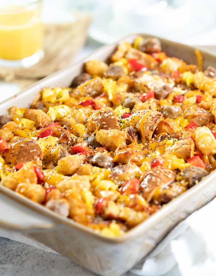 Overnight everything bagel casserole in a casserole dish with a glass of orange juice in the background.