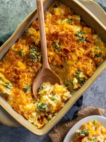Chicken Broccoli Rice Casserole in a brown casserole dish with a spoon scooping some up.