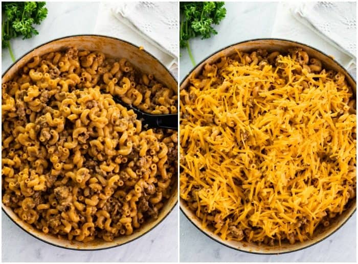 Elbow macaroni in a dutch oven being topped with shredded cheese for cheeseburger casserole.