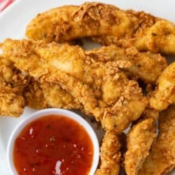 A labeled image of Fried Chicken Tenders on a white plate with dipping sauce.