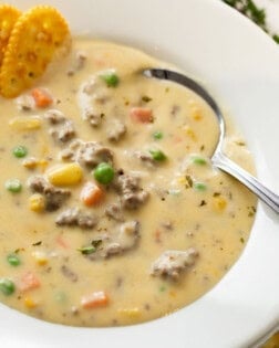 A spoon in a white bowl full of creamy Shepherd's Pie Soup.