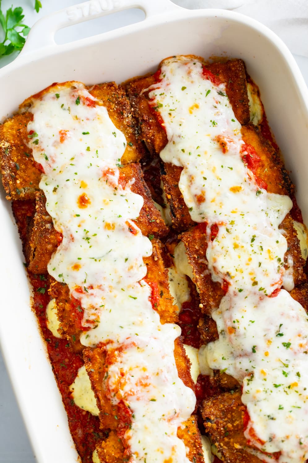 Eggplant Rollatini in a casserole dish with marinara and mozzarella on top.