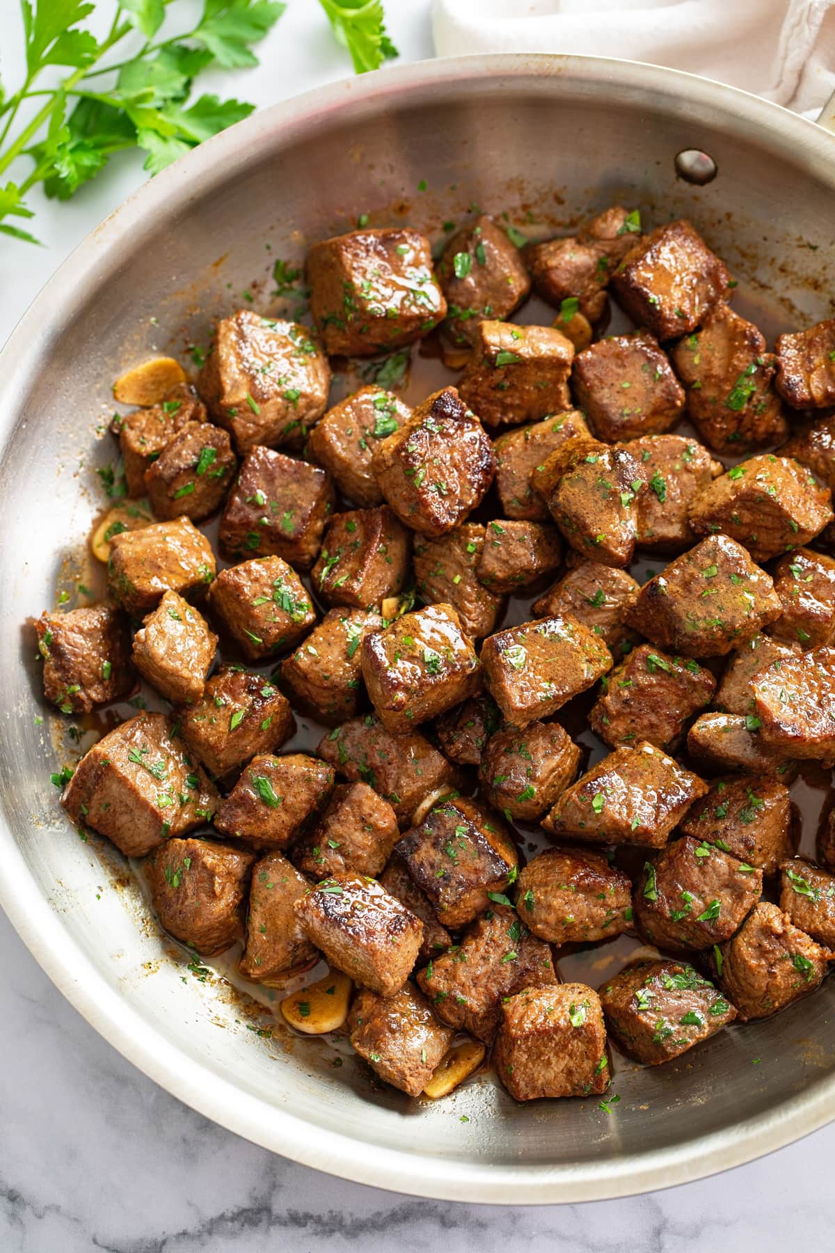 A skillet of Steak Bites in a Garlic Butter Sauce.