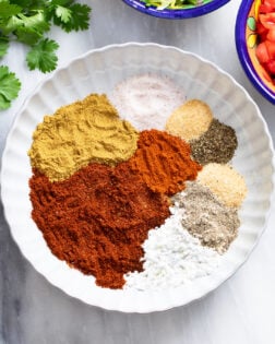 Taco seasonings in a white bowl before being combined together.